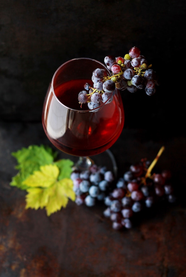 a filled wine glass with grapes on top