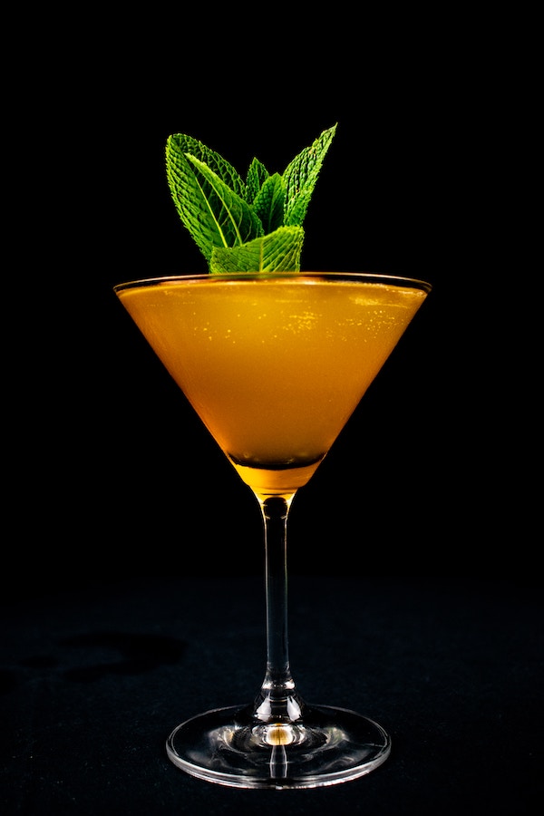 an orange cocktail with mint on top