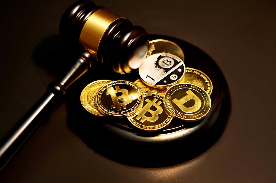 a judge hammer with cryptocurrency icons